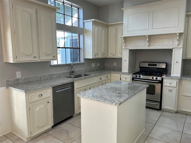 kitchen with a center island, gas stove, a sink, light stone countertops, and dishwasher