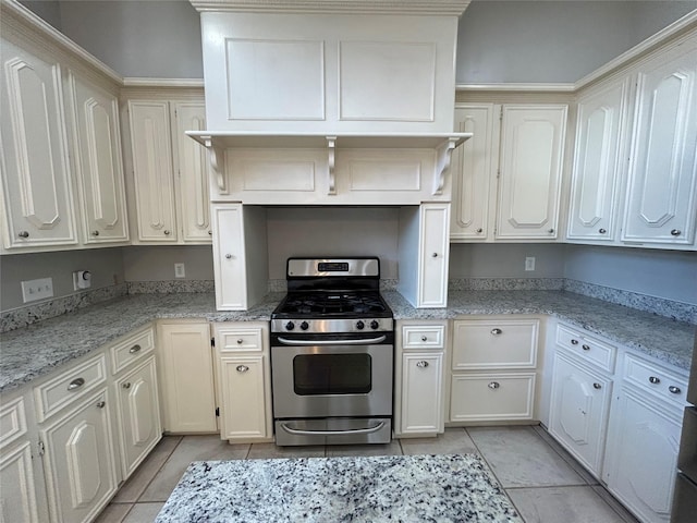 kitchen featuring light tile patterned floors, stainless steel gas stove, and light stone countertops