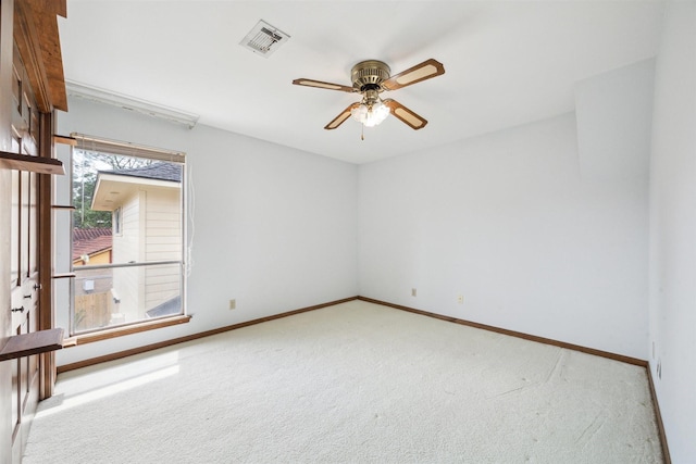 carpeted empty room featuring visible vents, ceiling fan, and baseboards