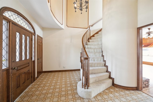 entryway featuring a high ceiling, stairway, and baseboards