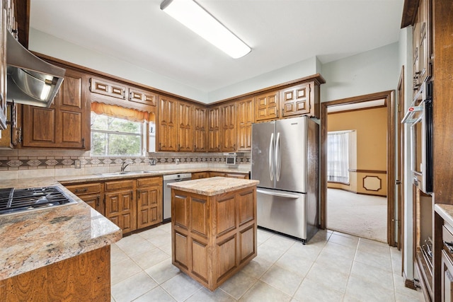 kitchen featuring a center island, decorative backsplash, appliances with stainless steel finishes, a sink, and extractor fan