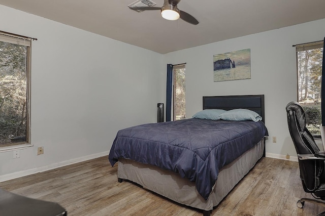 bedroom featuring ceiling fan, light wood-type flooring, visible vents, and baseboards