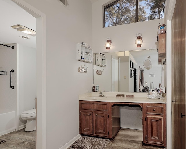 bathroom featuring shower / tub combination, toilet, wood finished floors, visible vents, and vanity