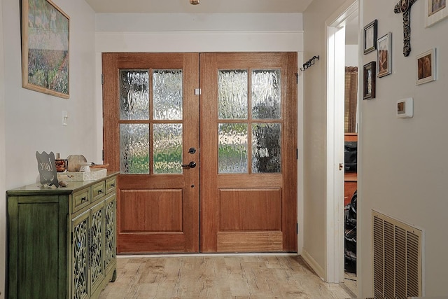 doorway to outside with french doors, light wood-style flooring, and visible vents