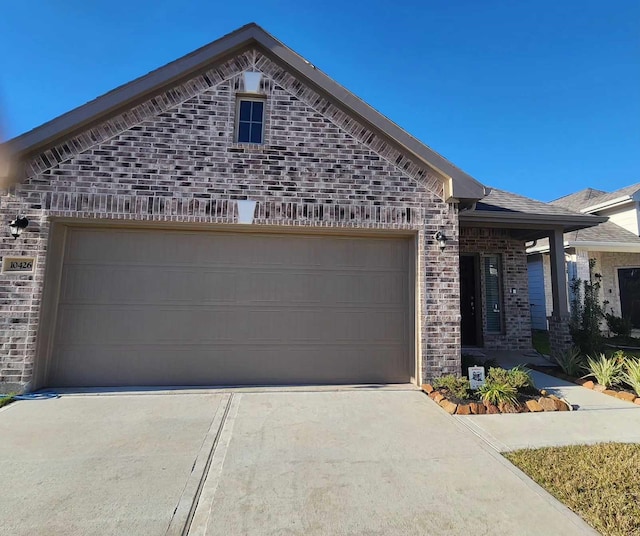 french provincial home with concrete driveway, brick siding, and an attached garage