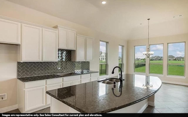 719 Woodbinde Dr, League City, TX 77573 - kitchen with hanging light fixtures, a center island with sink, white cabinetry, and a sink