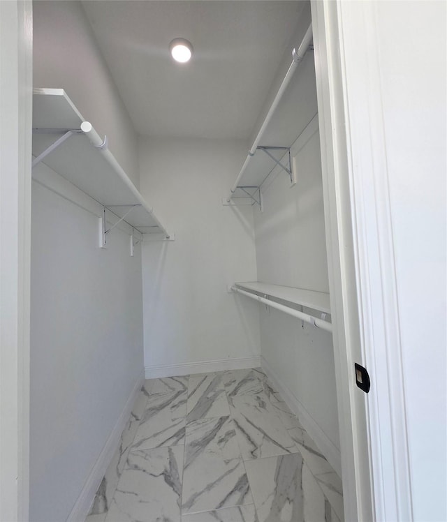 spacious closet featuring marble finish floor