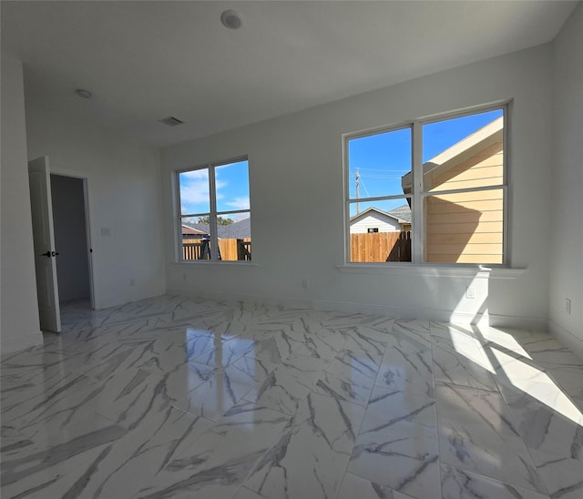 unfurnished room with marble finish floor and visible vents