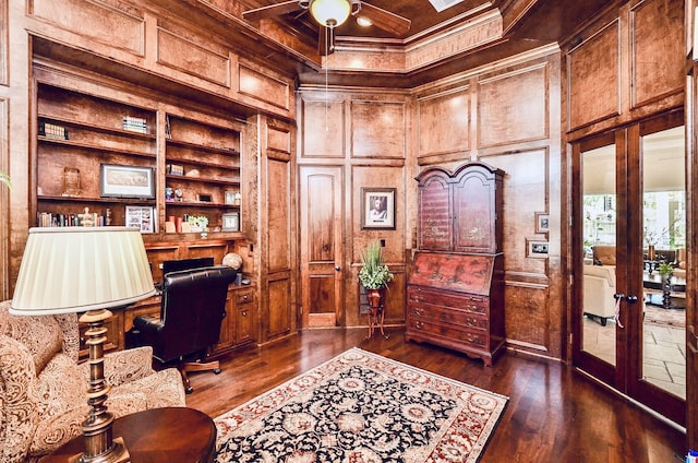 office featuring built in shelves, built in desk, ornamental molding, dark wood-type flooring, and ceiling fan