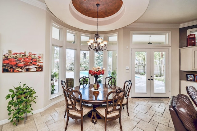 dining area featuring french doors, crown molding, stone tile flooring, a raised ceiling, and baseboards