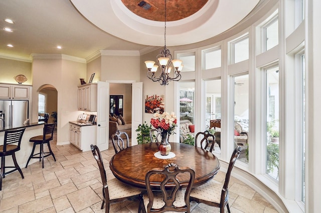 dining area featuring arched walkways, visible vents, a towering ceiling, stone tile flooring, and crown molding