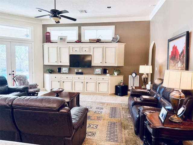 living area with ceiling fan, arched walkways, visible vents, french doors, and ornamental molding