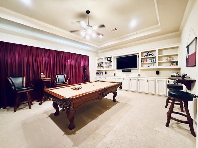 rec room featuring light carpet, visible vents, a raised ceiling, and ornamental molding