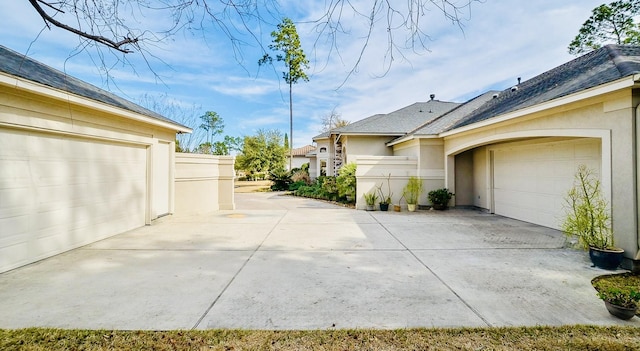 view of home's exterior with a garage, driveway, and stucco siding