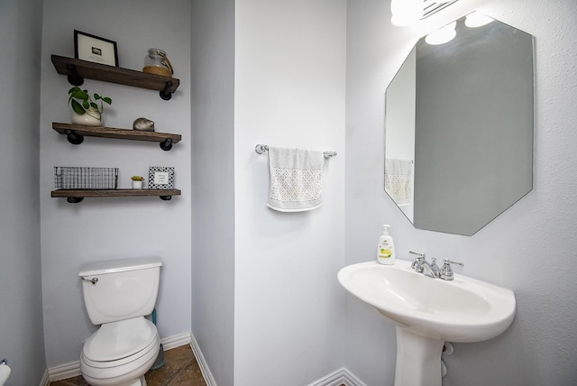 half bath with toilet and baseboards