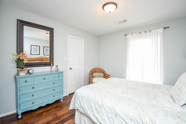 bedroom featuring dark wood-type flooring, visible vents, and baseboards