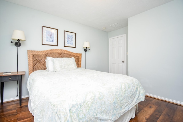 bedroom with dark wood finished floors and baseboards