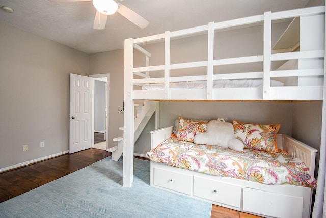 bedroom featuring wood finished floors, a ceiling fan, and baseboards