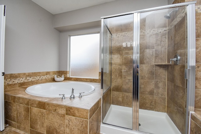 bathroom featuring a shower stall and a bath