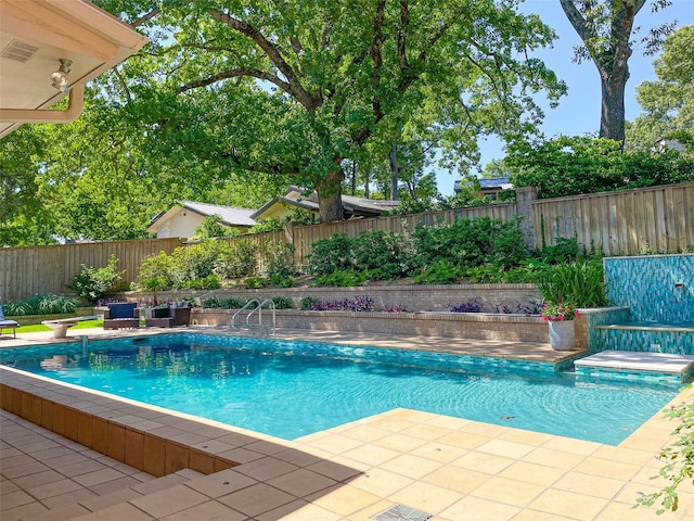 view of swimming pool featuring a fenced in pool, a fenced backyard, and a patio