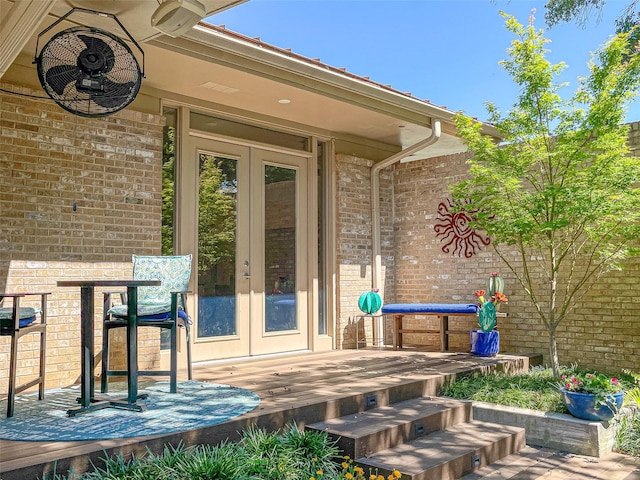 view of exterior entry with brick siding and french doors