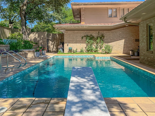 view of swimming pool featuring a fenced backyard, a diving board, and a fenced in pool