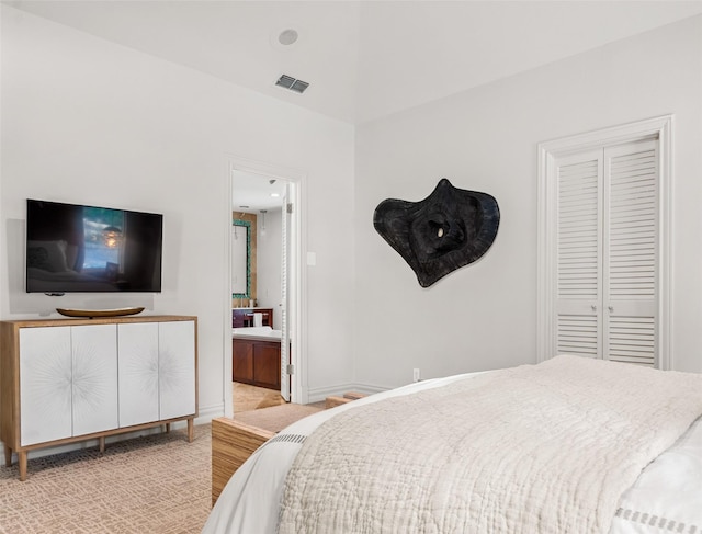 bedroom featuring light carpet, baseboards, visible vents, and ensuite bathroom