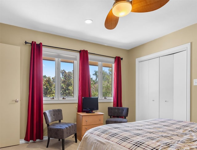 bedroom with ceiling fan, baseboards, a closet, and light colored carpet