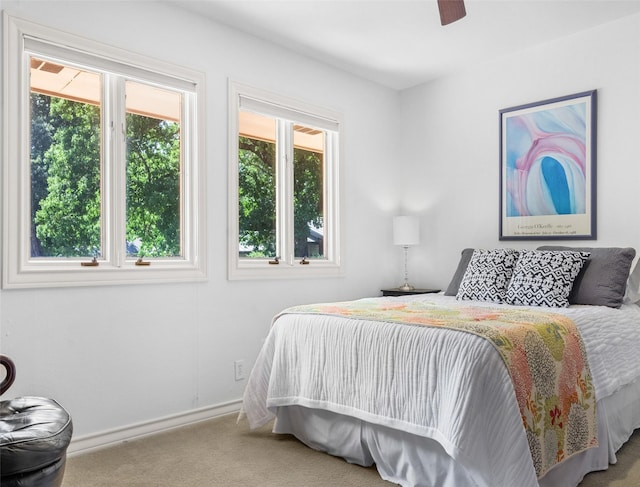 bedroom featuring light carpet, ceiling fan, and baseboards