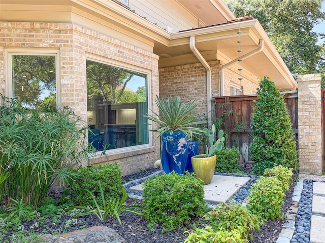 exterior space featuring brick siding and fence