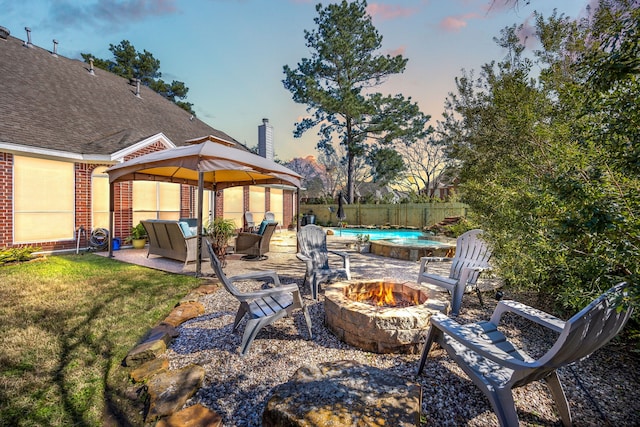 view of patio / terrace featuring fence, a fire pit, and a fenced in pool