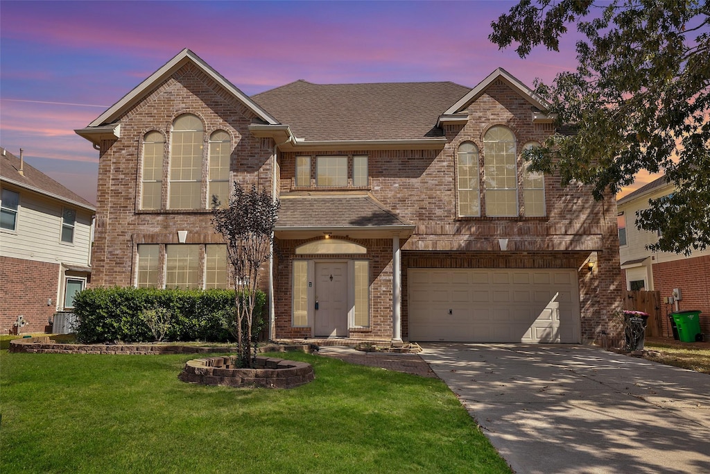 view of front of house featuring an attached garage, concrete driveway, brick siding, and a front yard