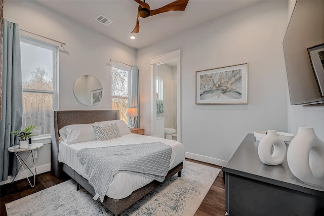 bedroom featuring dark wood-style flooring, visible vents, connected bathroom, and baseboards