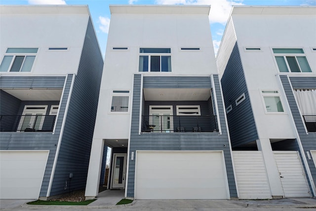 view of front of house featuring an attached garage, concrete driveway, and stucco siding