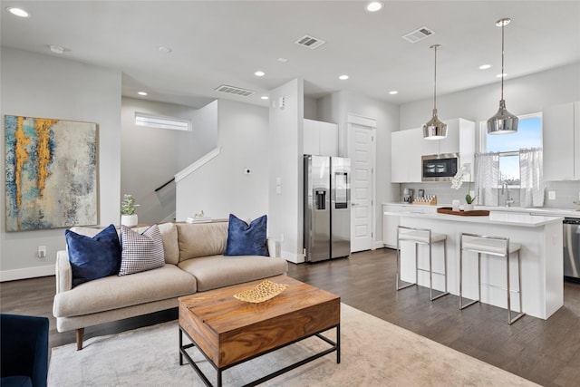 living area featuring dark wood-type flooring and visible vents