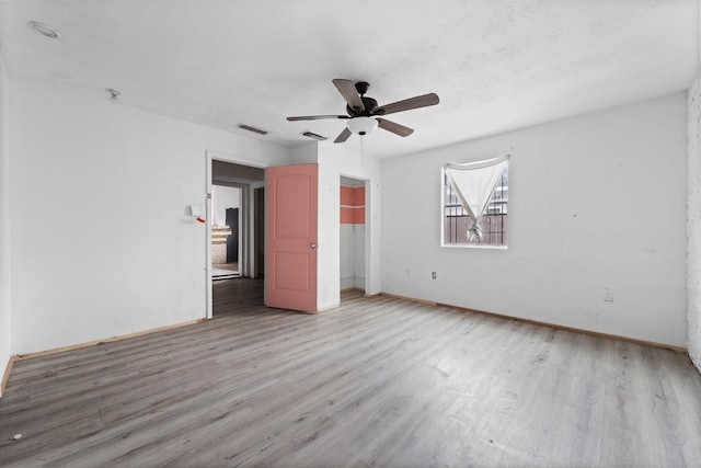 unfurnished bedroom with light wood-style floors, ceiling fan, visible vents, and a closet