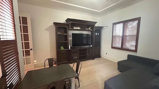 living room with light wood-style floors, baseboards, and ornamental molding