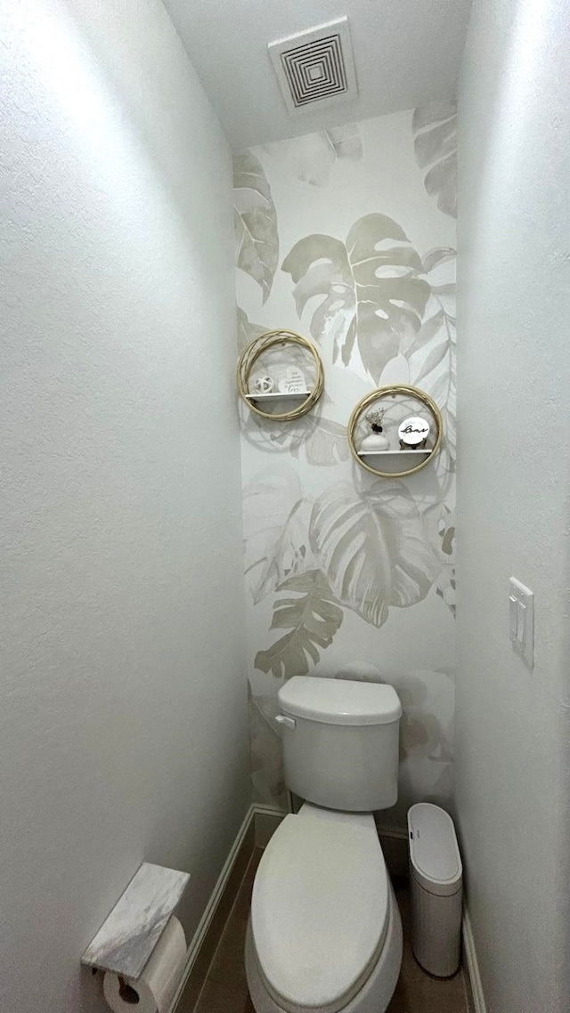 bathroom featuring toilet, visible vents, and baseboards