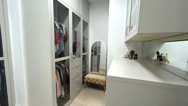 walk in closet with light wood-style flooring