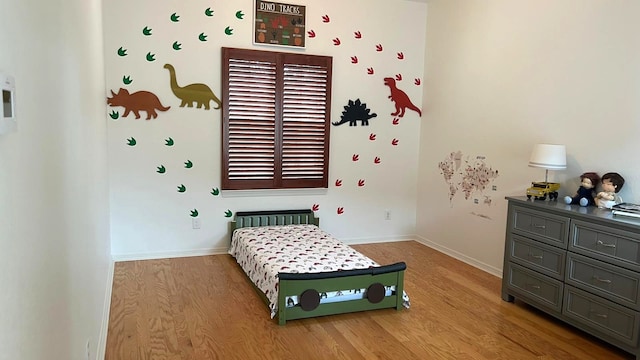 bedroom featuring baseboards and light wood finished floors