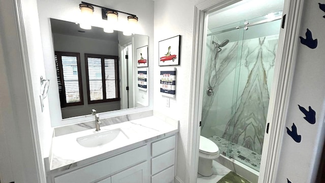 bathroom featuring toilet, vanity, and a marble finish shower