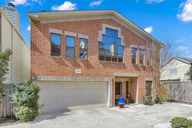 view of front facade with driveway, an attached garage, fence, and brick siding