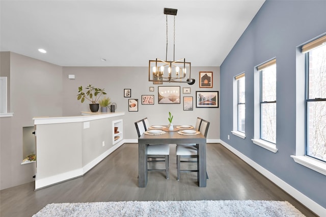 dining space with baseboards, dark wood finished floors, and a notable chandelier