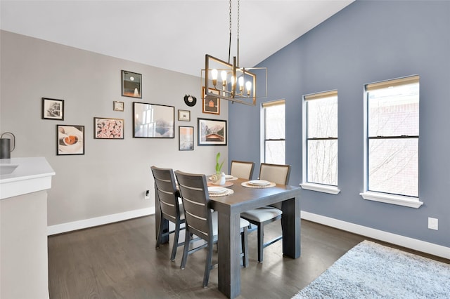 dining room with a notable chandelier, baseboards, vaulted ceiling, and dark wood-style flooring