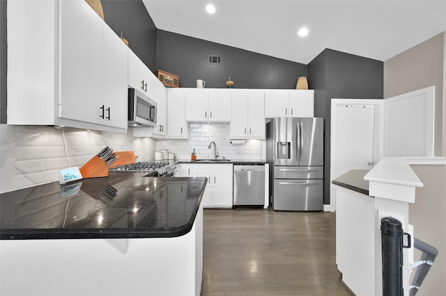 kitchen featuring a peninsula, visible vents, white cabinets, appliances with stainless steel finishes, and dark countertops