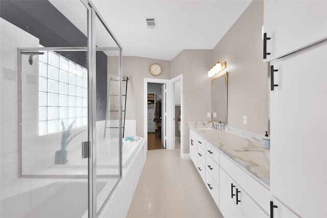 bathroom featuring a stall shower, visible vents, plenty of natural light, and double vanity