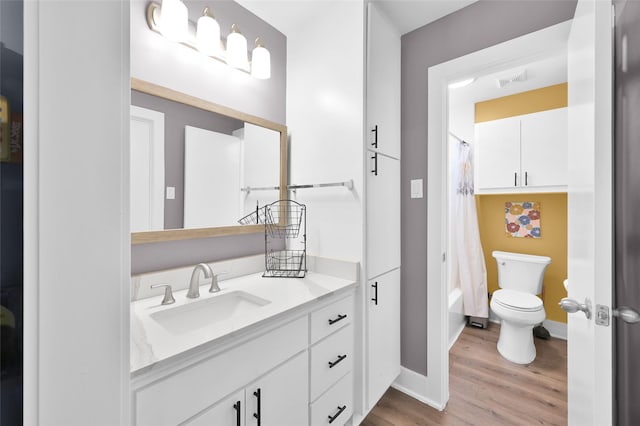 full bath with toilet, wood finished floors, vanity, baseboards, and shower / bath combination with curtain