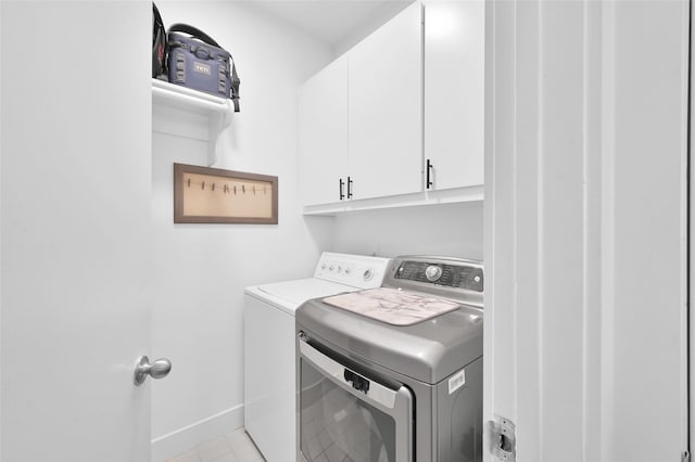 laundry room featuring washer and dryer, cabinet space, and baseboards