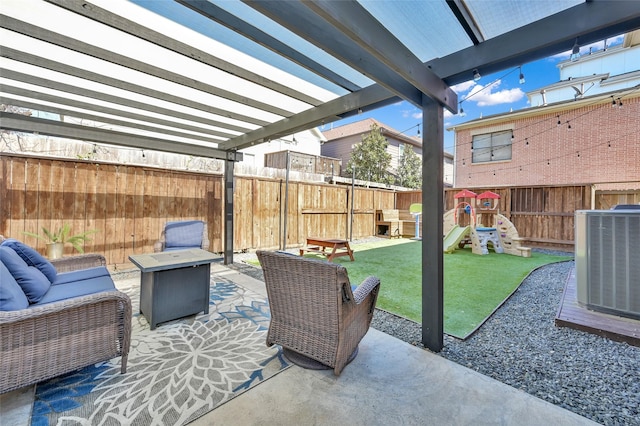 view of patio with a fenced backyard, central AC, a playground, and an outdoor living space with a fire pit