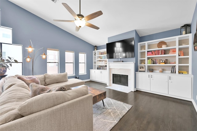 living area with lofted ceiling, ceiling fan, dark wood-type flooring, and a premium fireplace